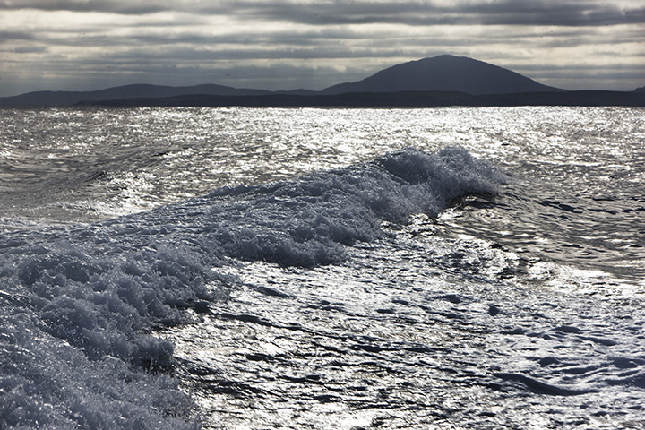 St Kilda: The Island of Lewis seen behind the boat on the way to St Kilda