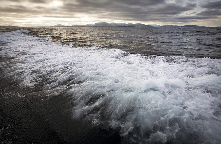 St Kilda: The Island of Lewis seen behind the boat on the way to St Kilda