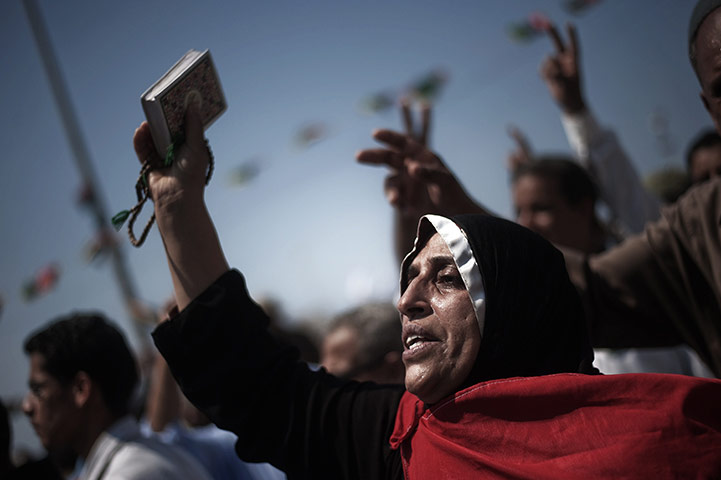 24 Hours: A woman at the funeral of three rebels killed during fighting in Brega