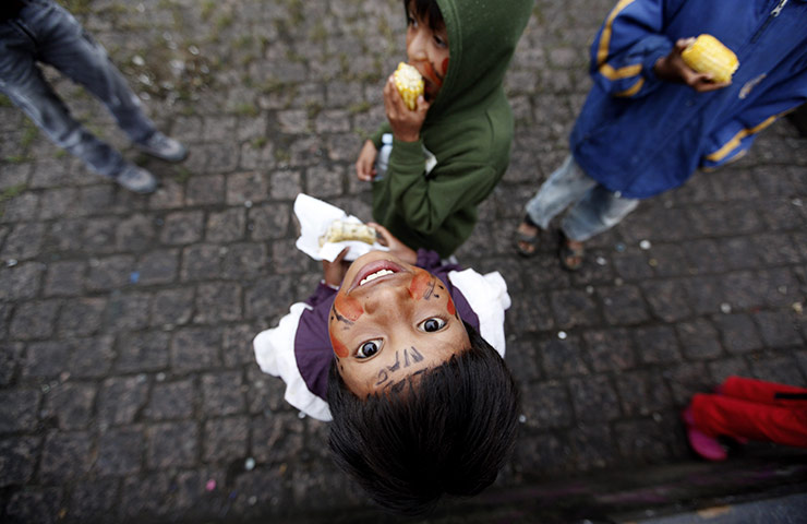 24 hours in pictures: Sao Paulo, Brazil: Brazilian indigenous children eat corn