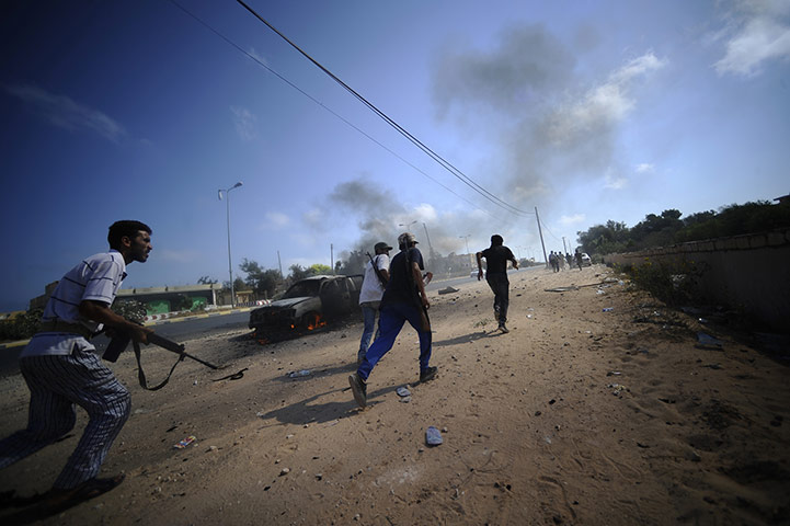 24 hours in pictures: Gadayem forest, Libya: Libyan rebels run for cover during fighting