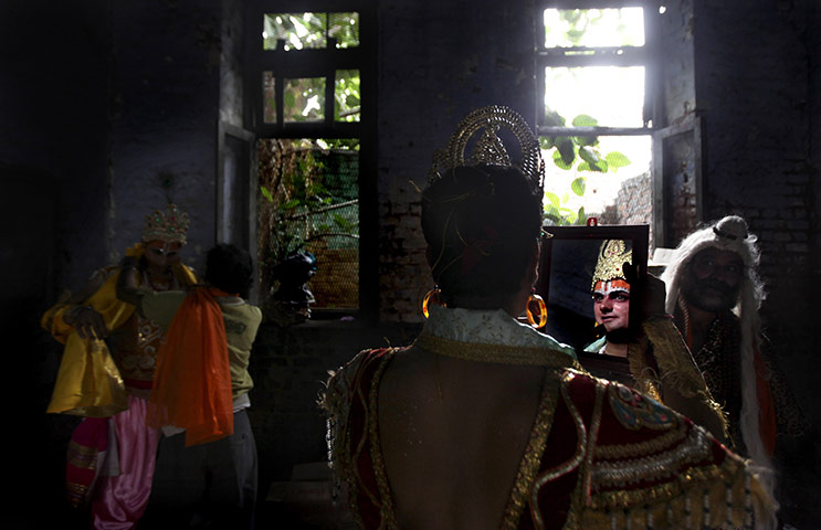 24 hours in pictures: Amritsar, India: A man dressed as Hindu god Krishna looks in a mirror 