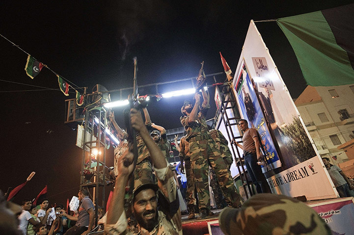 Muammar Gaddafi Libya : Libyan rebels security forces member fire their rifles in the air