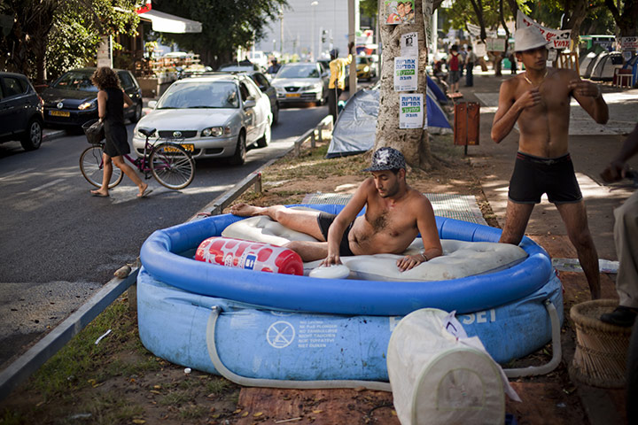 FTA: Oded Balilty: Israelis cool off in a pool at a protest tent encampment