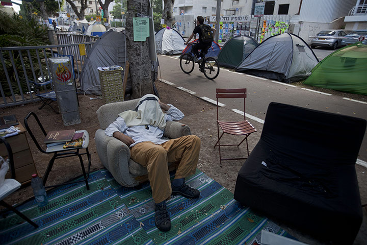 FTA: Oded Balilty: An Israeli protester sleeps on a couch in a protest tent encampment 