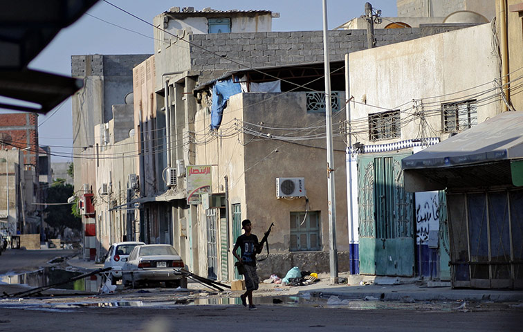 Battle for Tripoli: A rebel fighter walks in downtown Tripoli, Libya