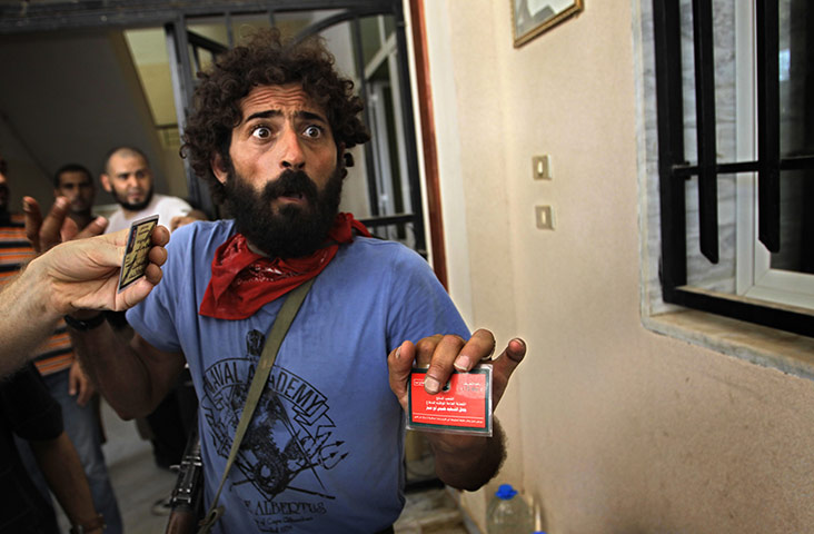 Battle for Tripoli: A rebel fighter holds the identification card of a pro-Gaddafi soldier 