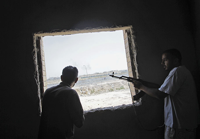 Battle for Tripoli: Rebel fighters observe the fighting near Muammar Gaddafi's main compound