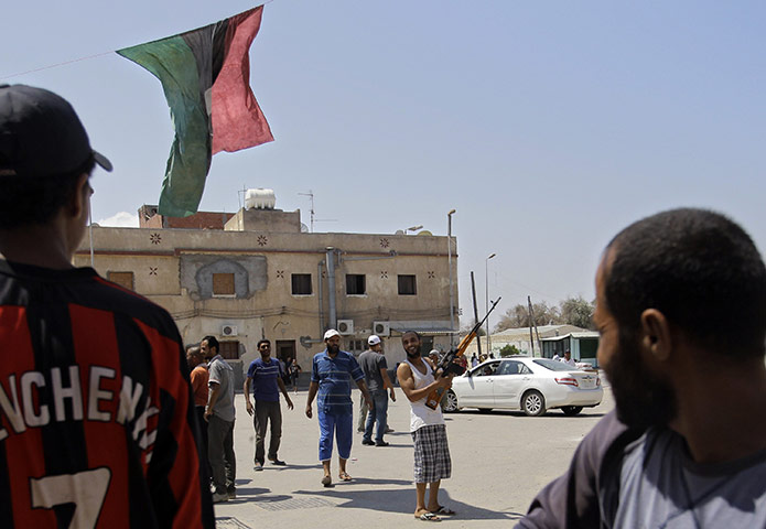 Battle for Tripoli: Rebel fighters gesture in the Gorgi district of Tripoli