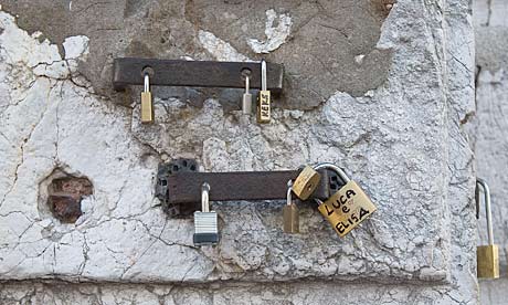 Love padlocks attached to a wall on Venice's Rialto bridge