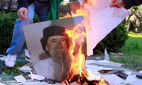 Employees of the Libyan Embassy burn a portrait of Gaddafi in Buenos Aires