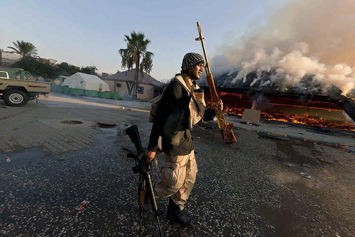 Gaddafi's compound falls: A rebel fighter displays a looted golden gun from the compound