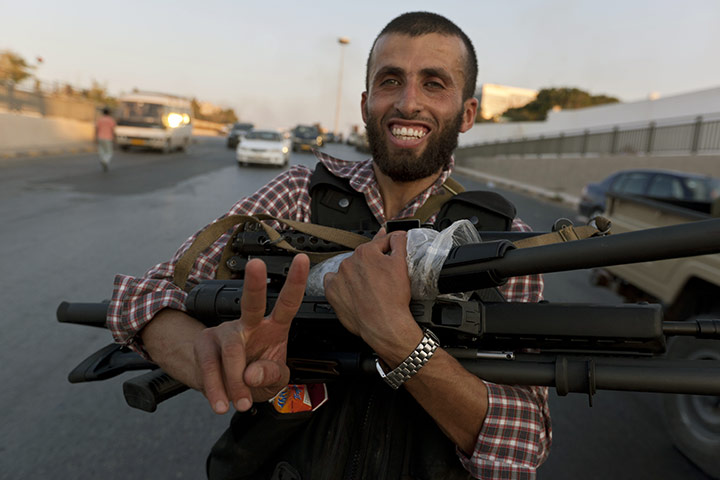 Gaddafi's compound falls: A rebel fighter with guns taken from the compound