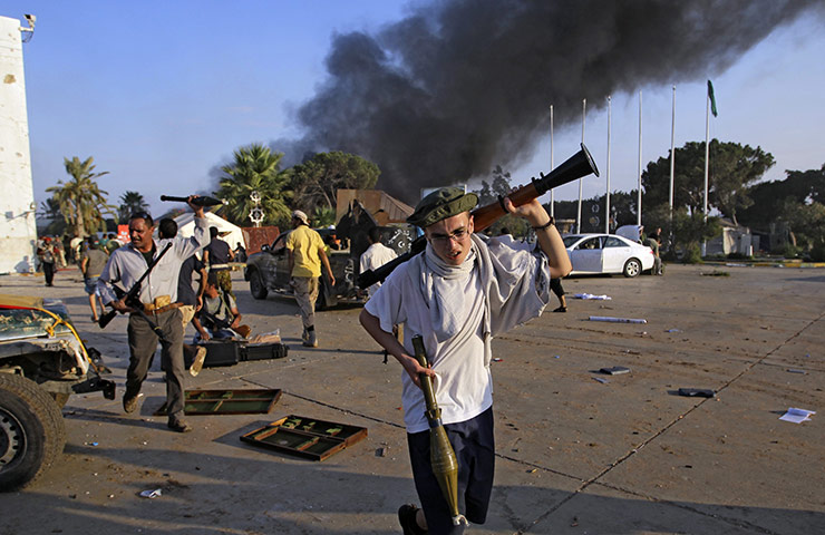 Gaddafi's compound falls: A rebel fighter carry a  gun inside the main Muammar Gaddafi compound 