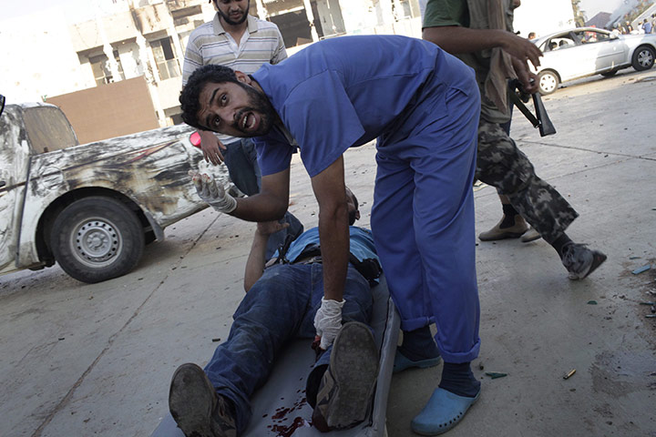 Gaddafi's compound falls: A doctor rescues a wounded rebel during the battle for the compound