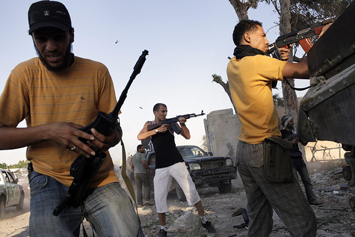 Gaddafi's compound falls: Libyan rebels shoot at Gaddafi supporters during the battle for compound