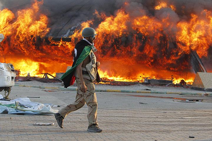 Gaddafi's compound falls: A Libyan rebel walks in the Bab al-Aziziya compound in Tripoli 