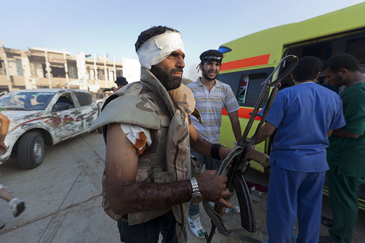 Gaddafi's compound falls: An injured fighter in the compound