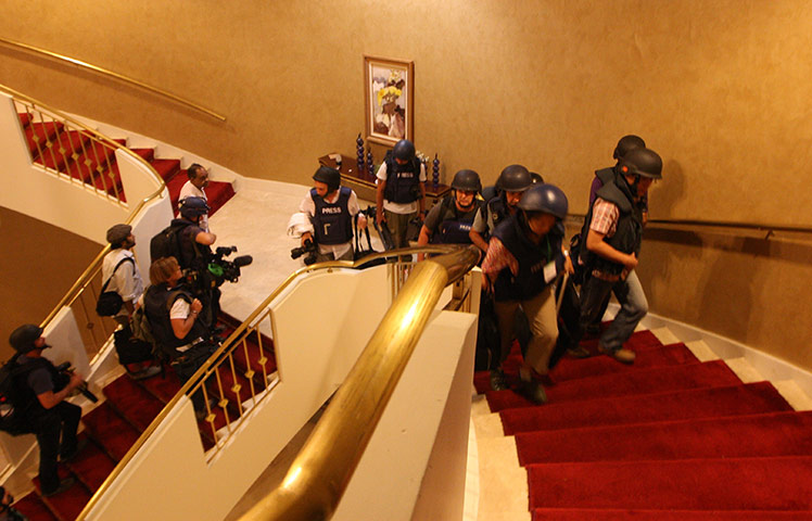 Media in Rixos hotel: Foreign journalists in protective gear are seen climbing the stairs