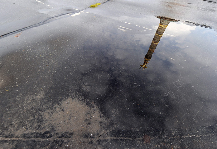 24 hours: Berlin, Germany: The Victory Column is reflected in a puddle after rain 