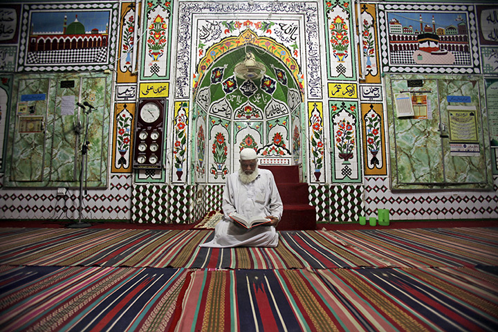 24 hours: Rawalpindi, Pakistan: A man reads verses of the Qu'ran 