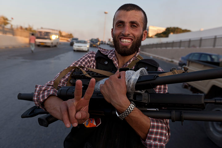 Sean Smith in Tripoli: A rebel fighter holds guns taken, Bab Al-Aziziya, Tripoli