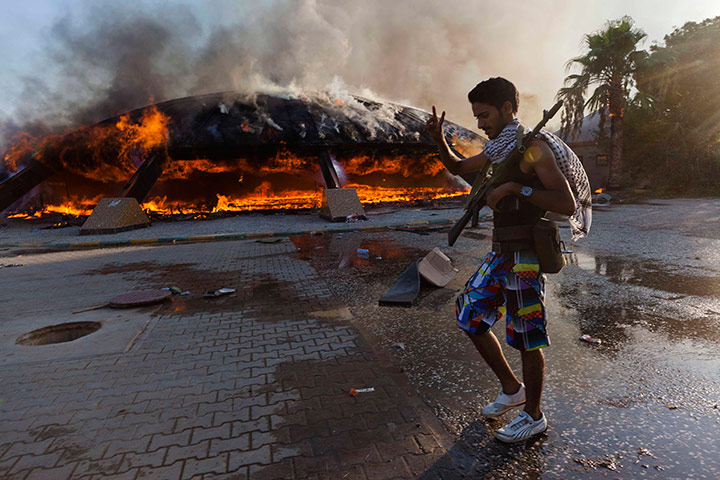 Sean Smith in Tripoli: Rebel walks past flames at the Bab Al-Aziziya compound