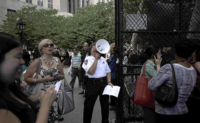 US earthquake: A law enforcement officer communicates to earthquake evacuees, New York 