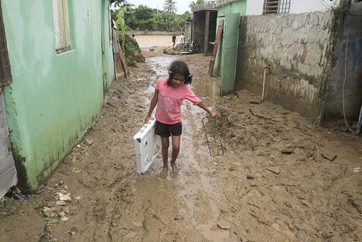 Hurricane Irene: A girl walks along a mud filled street after it was flooded by Nigua river