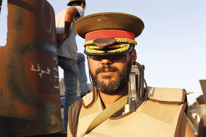 Raids in Tripoli: A Libyan rebel poses with a hat belonging to Muammar Gaddafi 