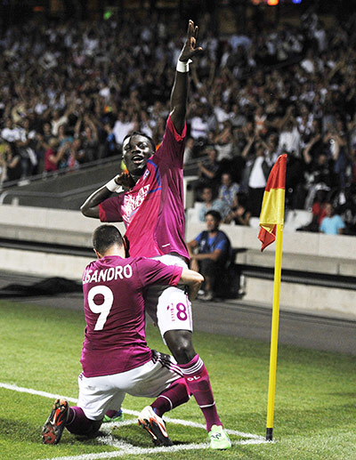Champions League Draw: Lyon's Bafetimbi Gomis, right, is congratuled by teammate Lisandro Lopez