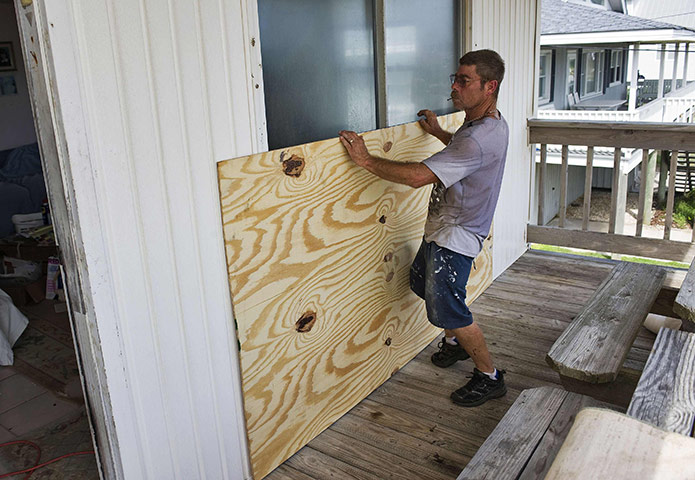 Hurricane Irene: Atlantic Beach, North Carolina: A resident boards up a glass door