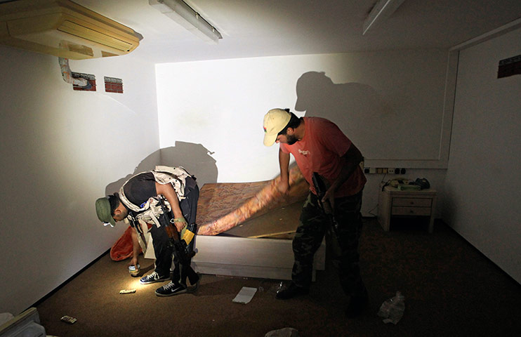 Bab al-Aziziya, Tripoli: Rebel fighters search a bedroom in the bunker, Bab al-Aziziya compound