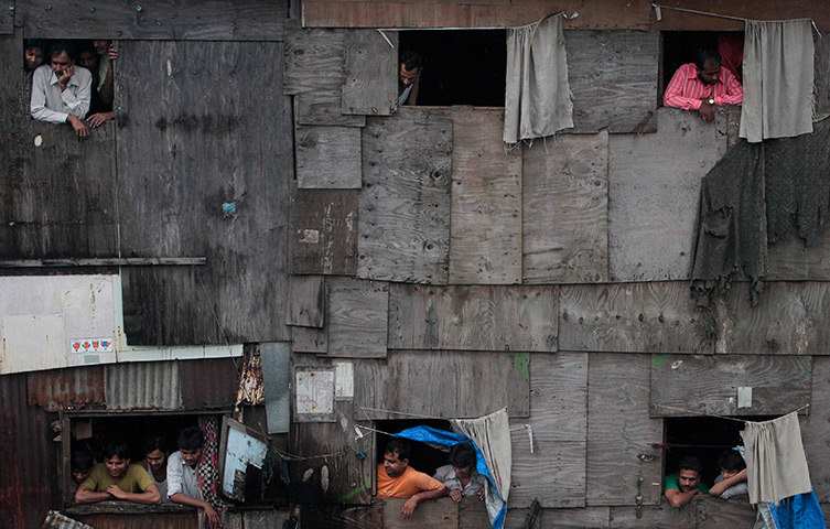 24 hours in pictures: People watch outside a shanty in Mumbai