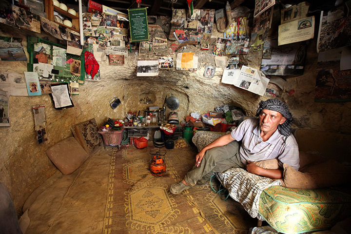 24 hours in pictures: Palestinian man its in the cave where he dwells