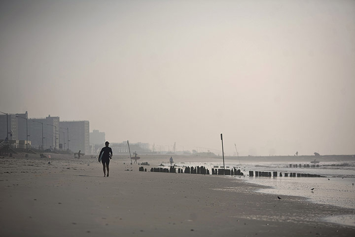 24 Hours: A man walks on the beach at Rockaway Beach in New York