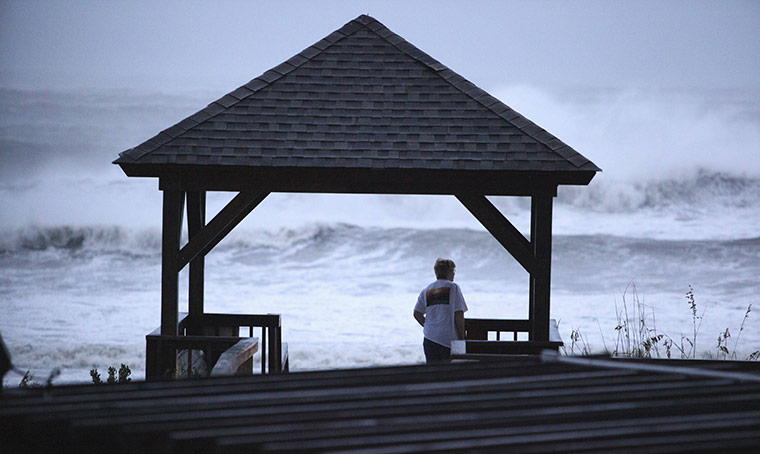 Irene Hurricane: A tourist checks out the surf  as Hurricane Irene passes through