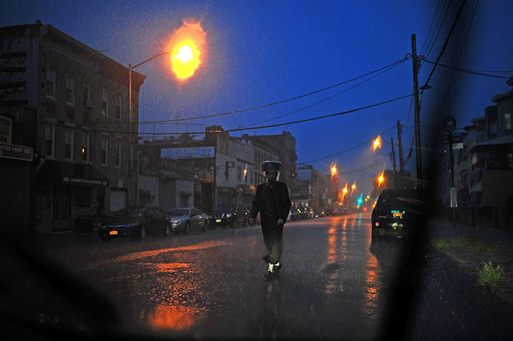 24 hours in pictures: A Hasidic Jew walks in rain as Hurricane Irene starts to hit in Brooklyn