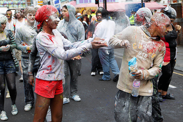 Notting Hill carnival: A reveler throws powder at the start of the Notting Hill Carnival