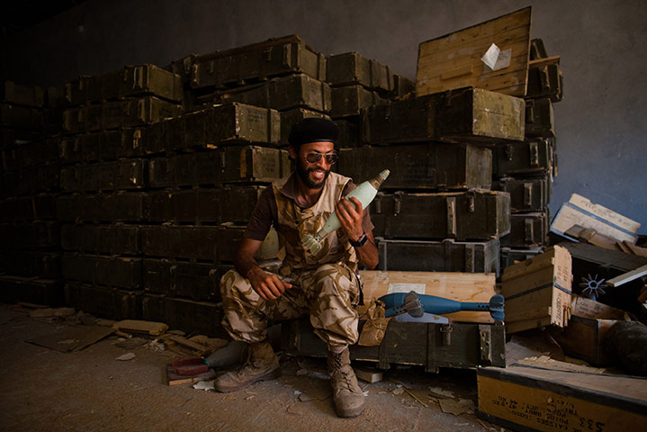 24 hours: Tripoli, Libya: Rebel fighter holds ammunition from one of Gaddafi's dumps