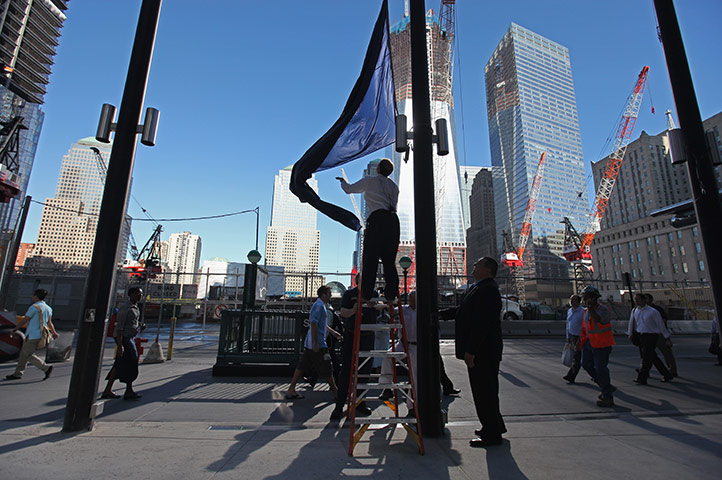 After Hurricane Irene: Millenium Hilton hotel staff raise New York flag in front of the hotel 