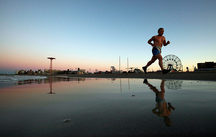 After Hurricane Irene: A man runs along the beach at Coney Island at dawn on in the Brooklyn 