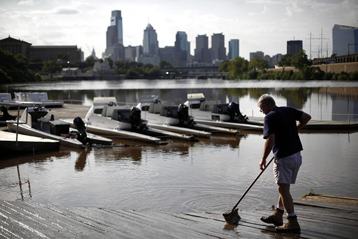 After Hurricane Irene: A man sweeps silt left behind from the floodwaters of the Schuylkill River 