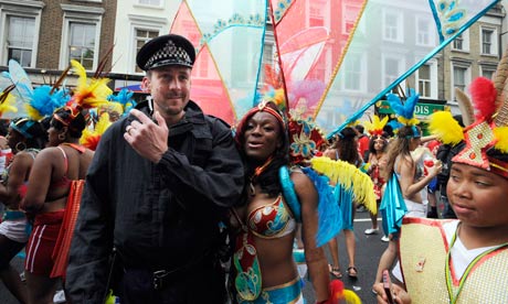 A Notting Hill carnival performer poses with a police officer on the second
