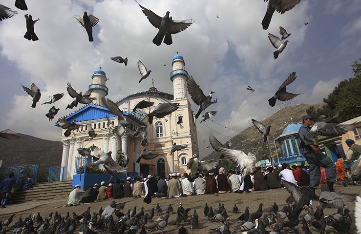 Eid al-Fitr: Kabul, Afghanistan: A policeman patrols as Muslims pray