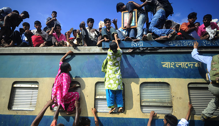 Eid al-Fitr: Dhaka, Bangladesh: People climb onto trains at the airport railway terminal