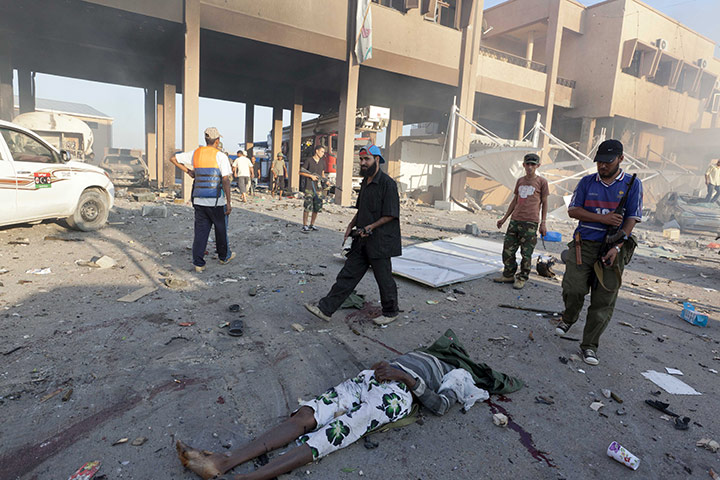 Sean Smith in Libya: 25 August: Rebel fighters pass the body of a man in the Abu Salim district