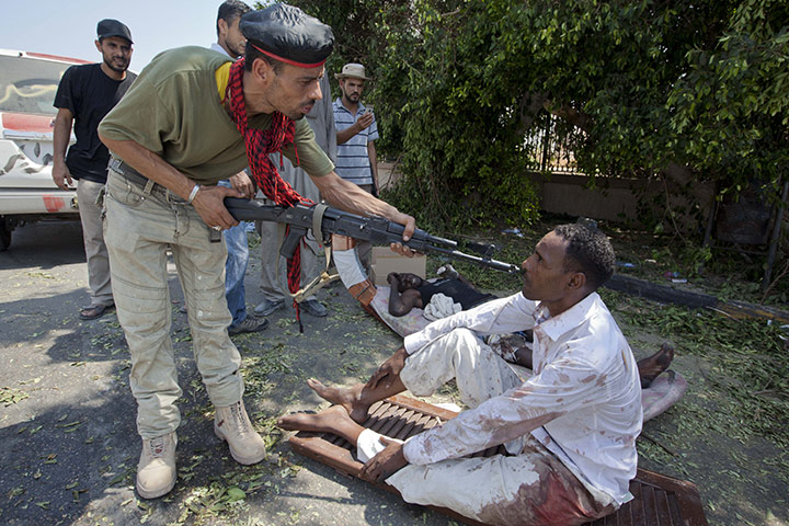Sean Smith in Libya: 26 August: A rebel soldier makes a point to a captured fighter at Abu Salim