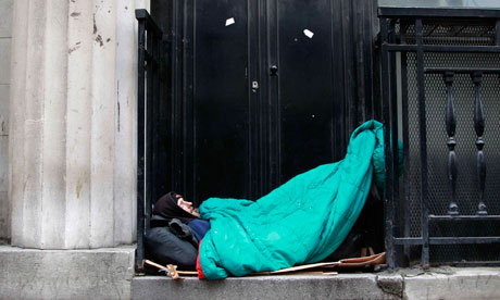 A homeless man sleeps in a doorway in central London