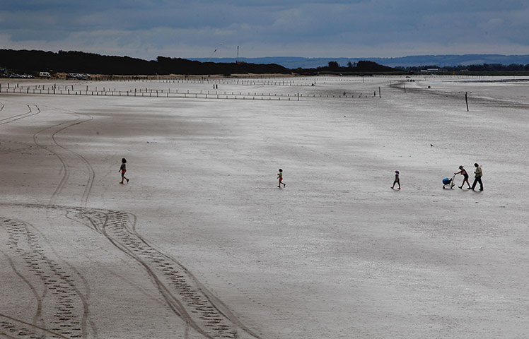 Summer 2011: Weston-Super-Mare:  People walk on the near deserted beach 